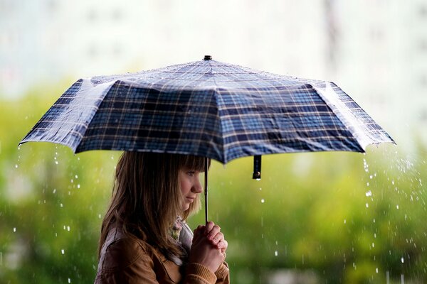 Fille brune avec parapluie sous la pluie