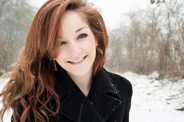 Red-haired girl on the background of a winter landscape