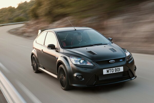 Ford focus on the side in motion against the background of a beautiful road