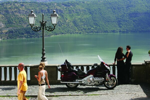 Pareja con una motocicleta en el paseo marítimo de la ciudad