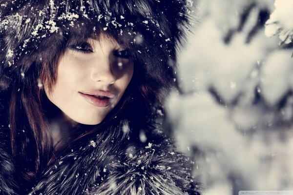 A woman in a fur coat in the forest in winter