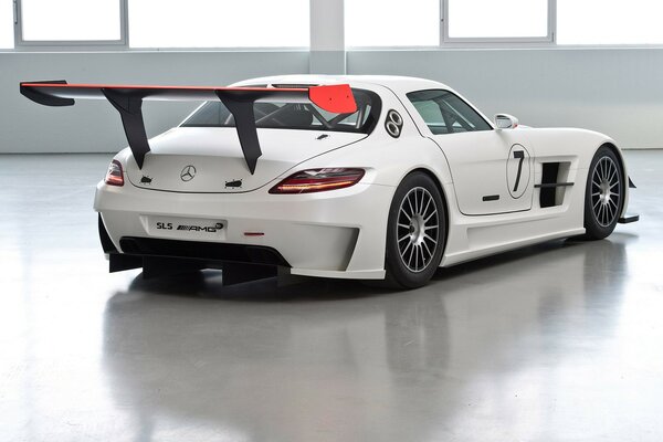 White racing Mercedes in a bright room on the trunk side