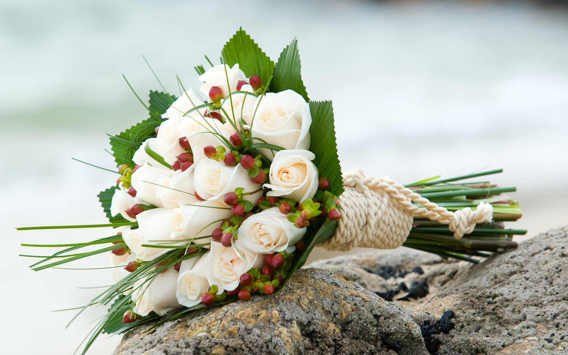 blumenstrauß blumen rosen weiß foto hochzeit urlaub steine strand meer wellen seil komposition weiße rosen hochzeitsstrauß