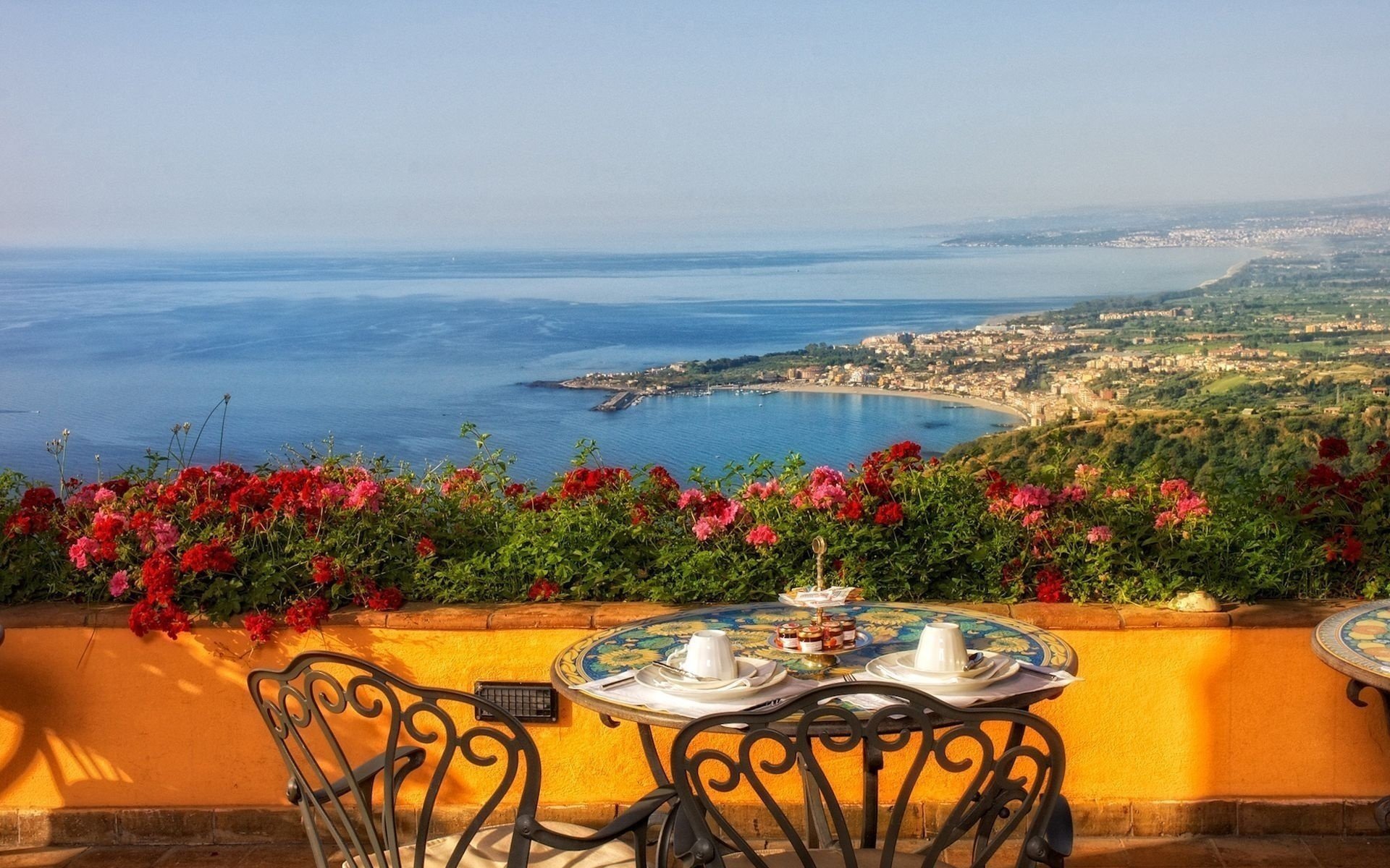 fleurs italie peinture balcon verdure vue paysage tasses table chaises thé matin petit déjeuner mer baie côte côte ciel horizon loisirs eau surface