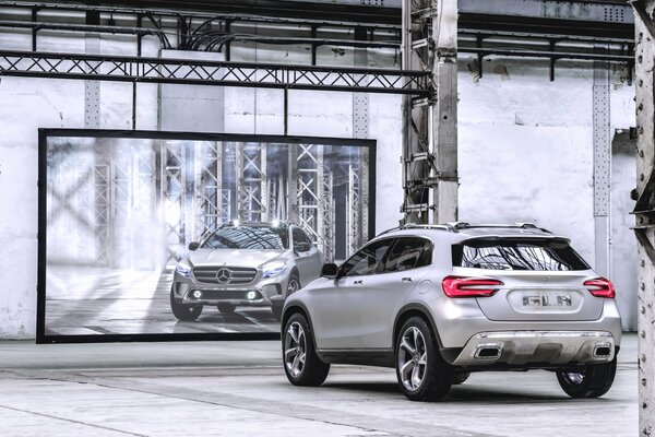Mercedes de plata frente al espejo en el hangar