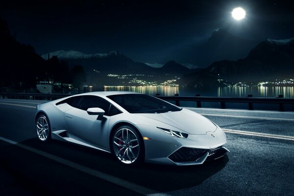 En el camino nocturno bajo la Luna-Lamborghini blanco