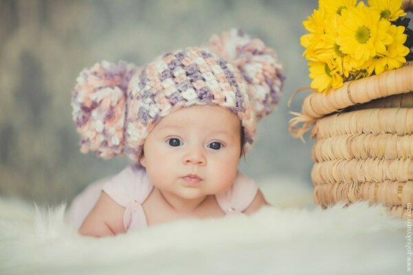 Baby in a hat on a fluffy blanket