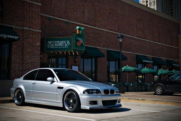 There is a silver BMW in the parking lot