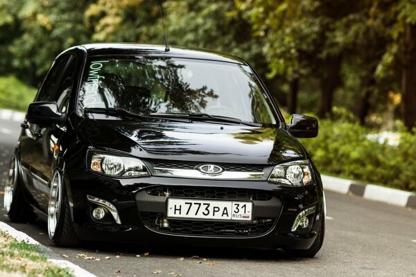 Coche negro Lada kalina parado en la carretera