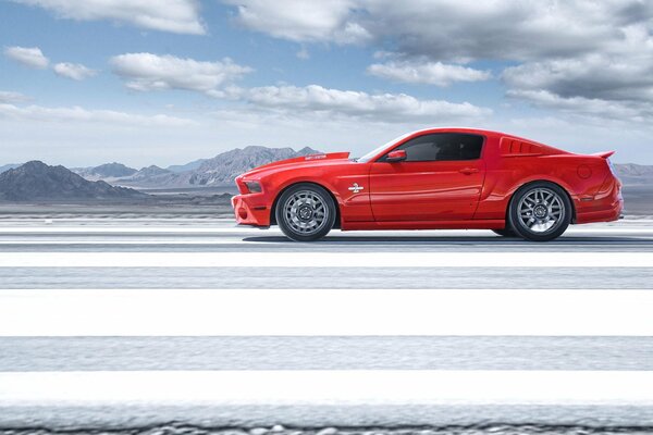 Pod chmurami jedzie czerwony Ford Mustang