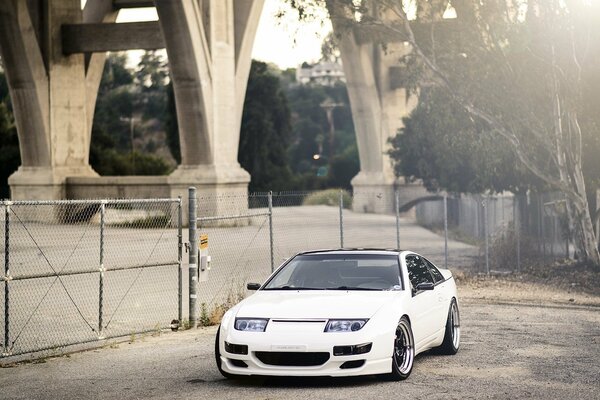 The white Nissan looks very low compared to the architecture of the city