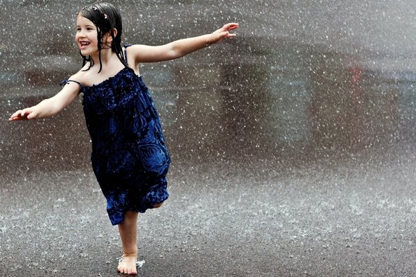 Petite fille danse sous la pluie d été