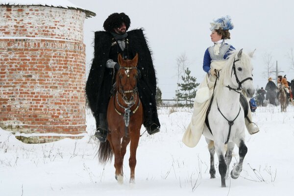 Mezhchina e donna in inverno a cavallo