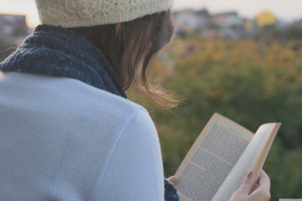 A girl reads a book in nature