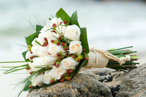 Bouquet da sposa di rose bianche su pietre