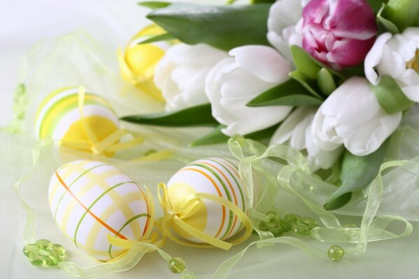 Huevos de Pascua en la mesa con tulipanes