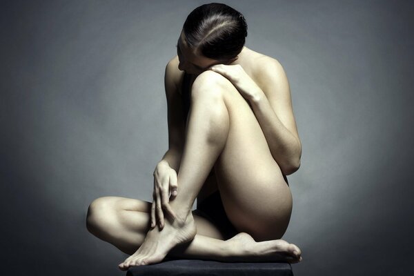 A girl sitting on the floor on a dark background