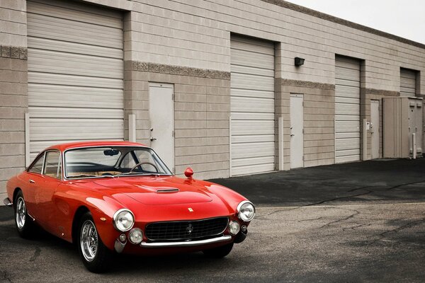 Rouge ferrari gt rétro près du garage