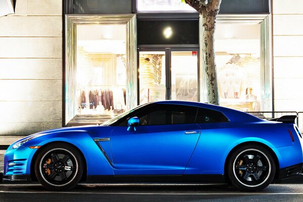 A motored blue Nissan parked in the city