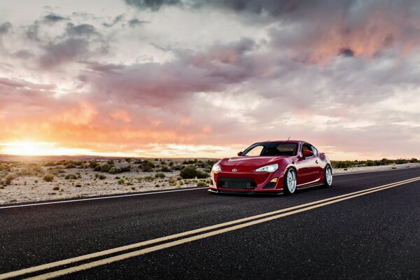 Red sports Toyota on the background of sunset