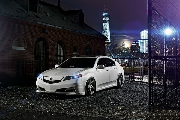 Honda blanco en el fondo de la ciudad nocturna