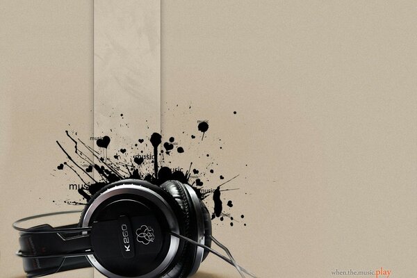 Black headphones on a beige background with black blots