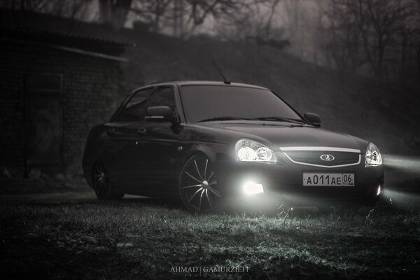 Understated Lada Priora with headlights on