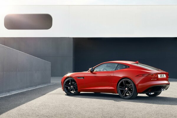 Rotes Auto Jaguar auf grauem Hintergrund