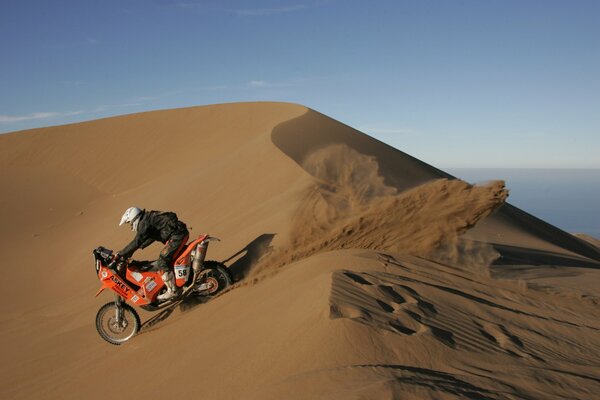 Мотоцикл ралли дакар преодолевает песчаный бархан