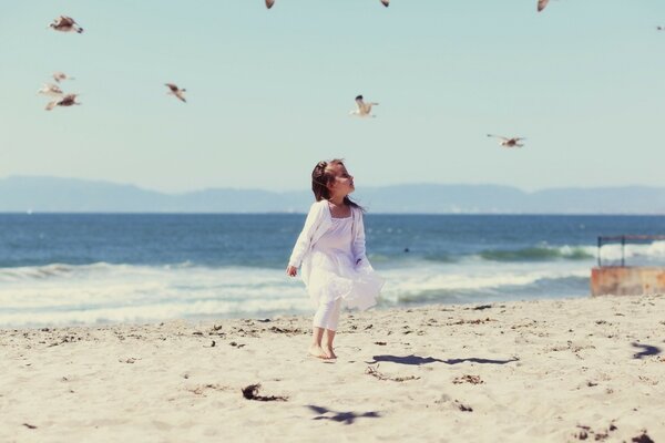 Mała dziewczynka biegnie po plaży