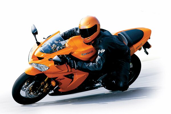 Helmeted pilot on an orange kawasaki zx-10r motorcycle