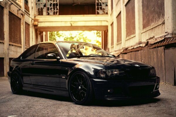 A black BMW parked in front of an old building