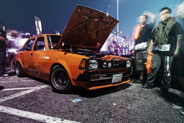 Orange Toyota Corolla. People on the move