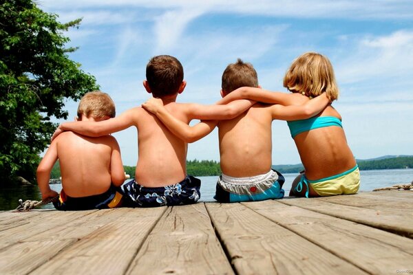 Quattro bambini seduti su un molo
