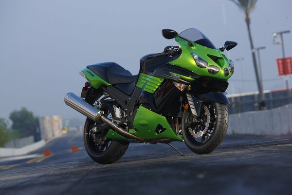 A sporty green motorcycle stands in the city