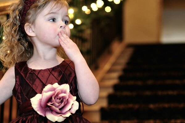 Photo of a child with a beautiful dress with a rose