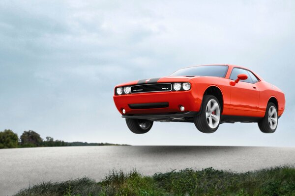 Orange challenger srt8 in the air at high speed