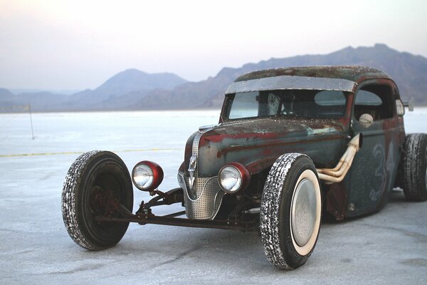 Old Ford car on the background of mountains