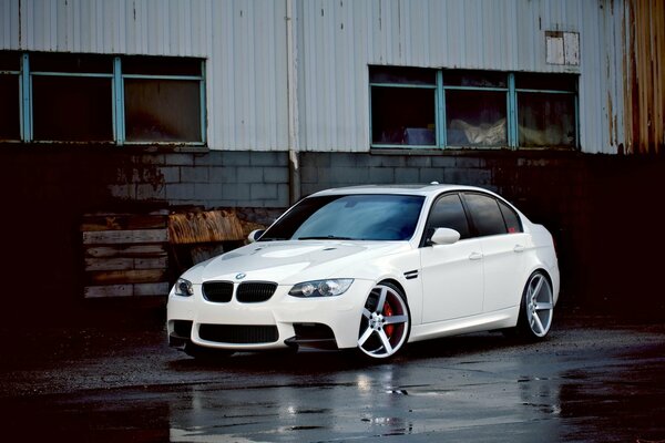 BMW blanco con Llantas plateadas después de la lluvia