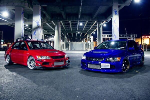 Two mitsubishi cars in the parking lot background