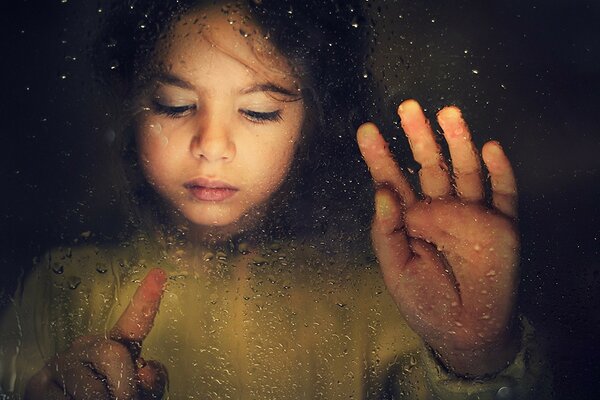 La jeune fille regarde comment les gouttes s échappent sur le verre