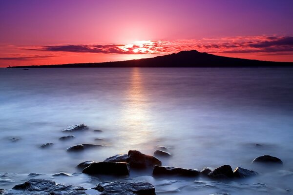 Brillante puesta de sol en el mar de ituman en las rocas