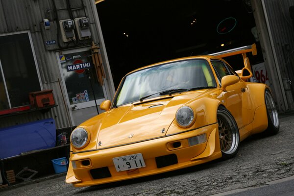Gelber Porsche steht auf dem Asphalt
