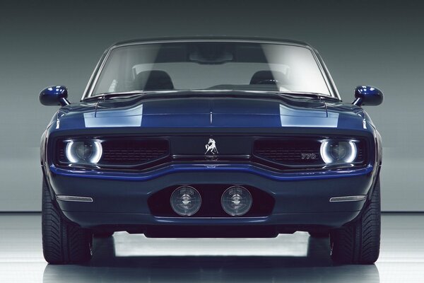 Un coche azul sobre un fondo blanco y gris se encuentra