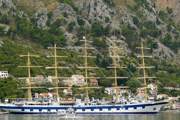 A huge ship is standing on the shore in front of the mountains