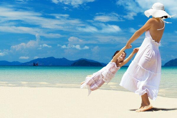 Maman avec bébé joyeusement jouer au bord de la mer