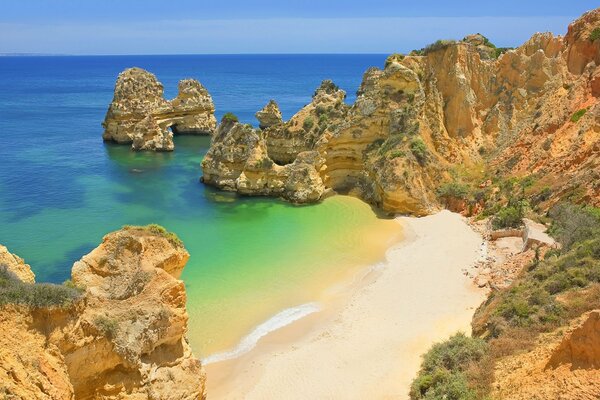 Bella spiaggia in riva al mare circondata da scogliere