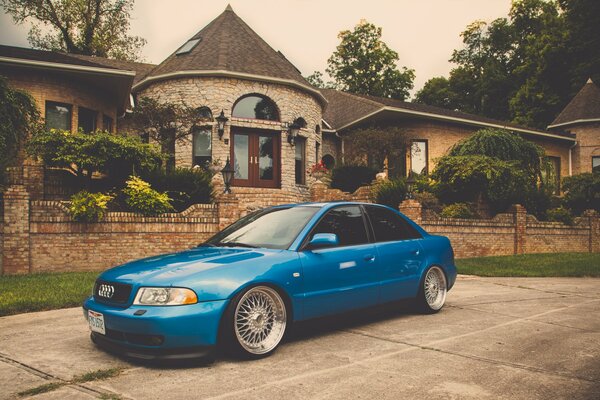 Blue audi on the background of the mansion