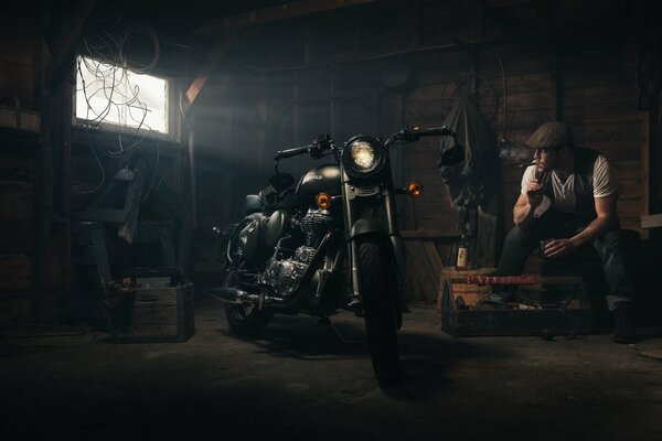 Hombre en el garaje con una motocicleta Royal Enfield