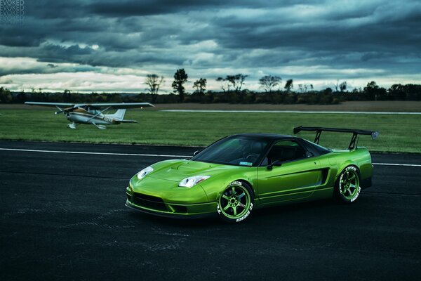 The green honla stands on the black asphalt